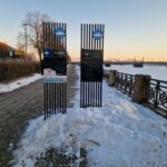 Reklāmas stendi krastmalā Rīgā, ap kuriem sakrājies nenotīrīts sniegs.